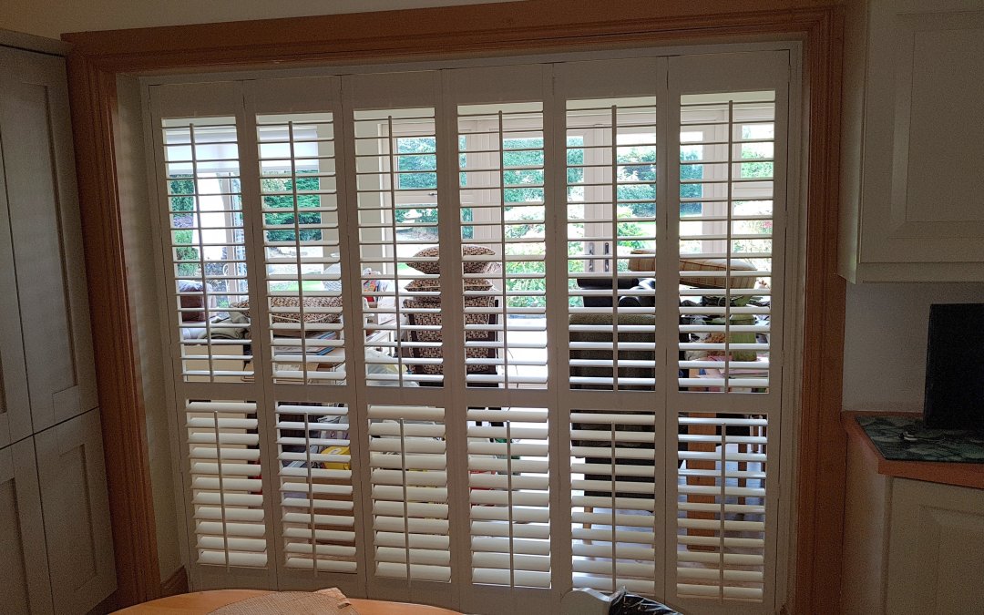 Plantation shutter installed between kitchen and dining room.