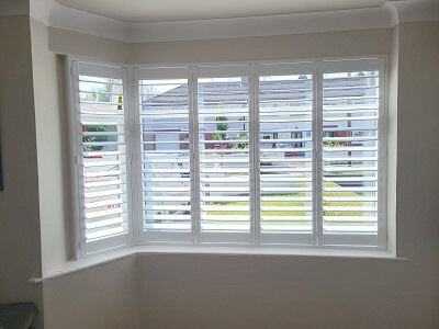 Corner window fitted with a pure white Plantation Shutter.